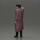 old man with pointed beard leaning against a wall in deep thought with his coat open - Only-Games