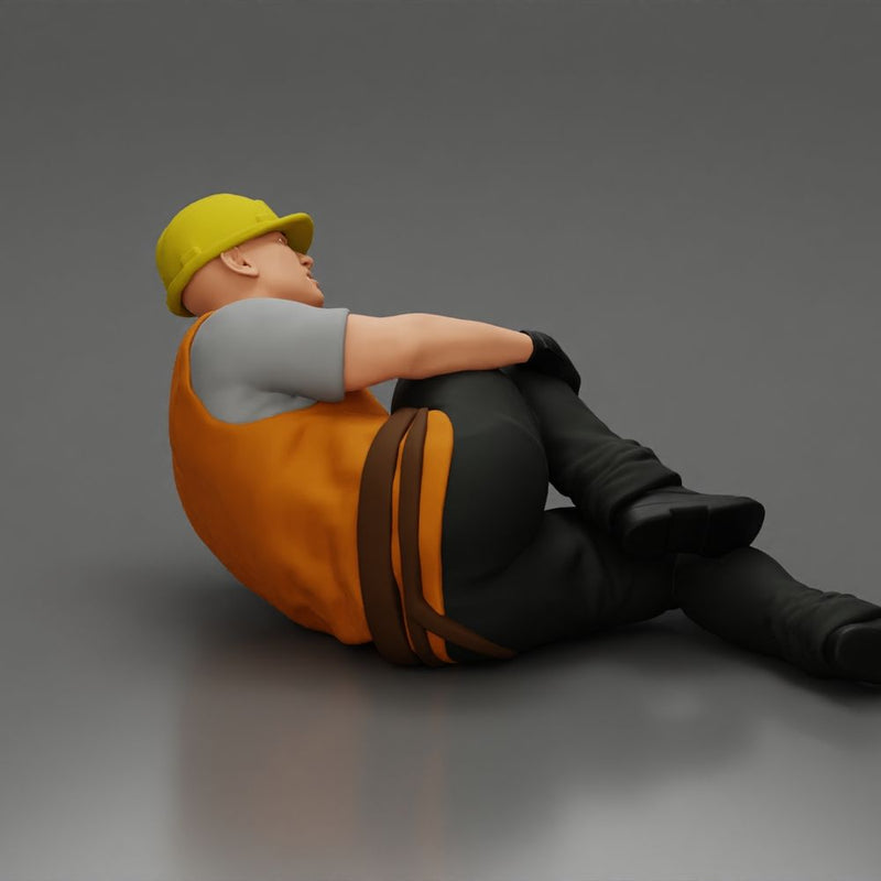 construction worker lying on the floor holding his injured leg