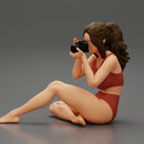 Woman photographer in bikini sitting and holding a camera - Only-Games