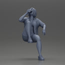 Young woman sitting on a chair hugging her pulled-up leg while drinking - Only-Games