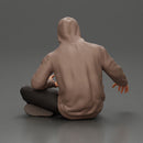 Contemplative man in hoodie sitting cross-legged, expressing curiosity thoughtfully - Only-Games