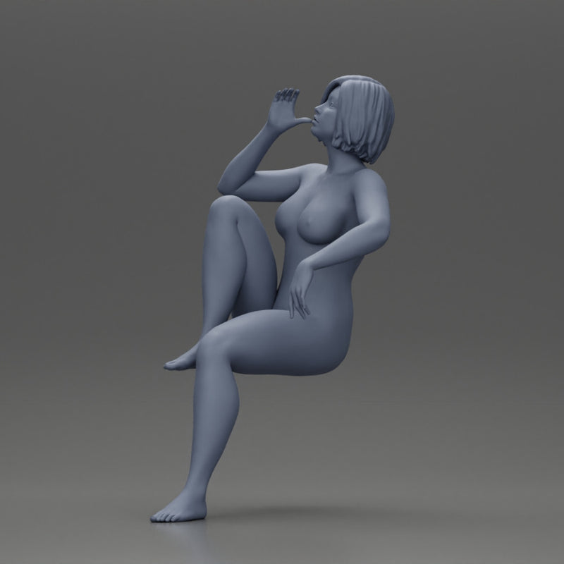 naked woman sitting on a chair hugging her pulled-up leg while drinking