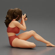 Woman photographer in bikini sitting and holding a camera - Only-Games