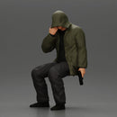 Man in hooded jacket sits alone holding gun feeling troubled - Only-Games