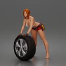 woman Pushing Tire In Bikini Top Shorts Tool Belt And Gloves