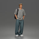 Student standing with backpack wearing oversized tee and baggy jeans