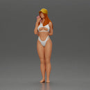 girl in a white bikini holding a phone on the beach and wearing a cap - Only-Games