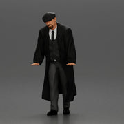 Man in black coat wearing flat cap standing with serious expression - Only-Games