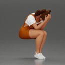 Crying girl sitting low in orange dress with head in hands - Only-Games