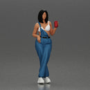 Woman with black hair wearing blue overalls holding a drink - Only-Games