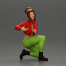 Fashionable woman kneeling in red jacket, green pants, and black boots - Only-Games