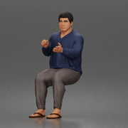 Asian Man sits gesturing while wearing casual sweater pants flip flops comfortably - Only-Games
