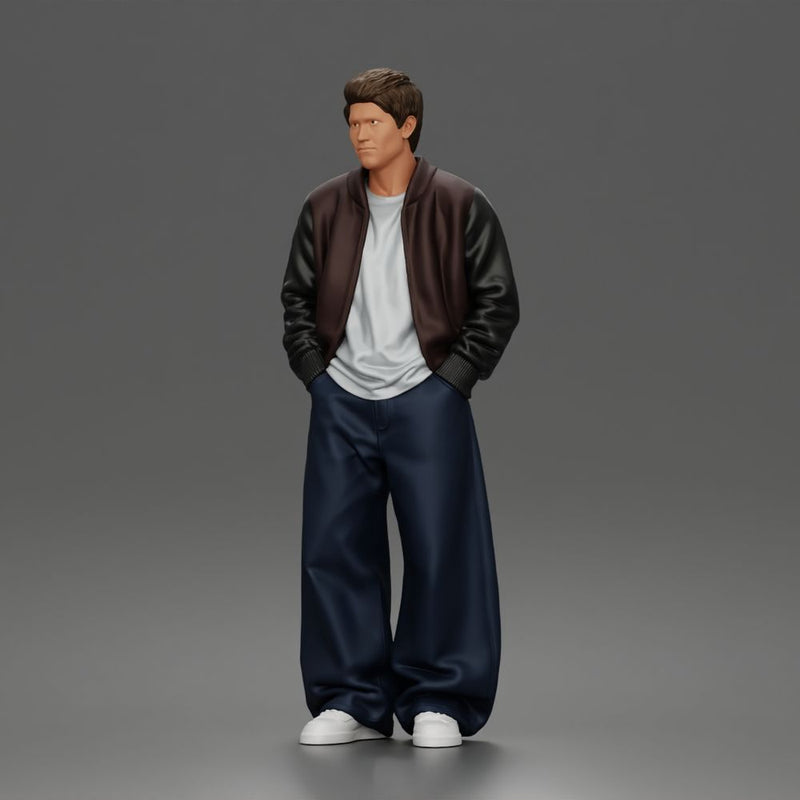 Urban male standing in varsity jacket and baggy trousers