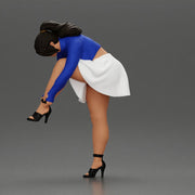 Young woman in skirt adjusts her elegant black high heeled shoes - Only-Games