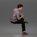 Man Sitting With Knee Bent In Shirt Trousers And Sandals
