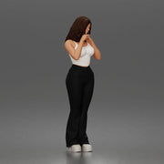 Thoughtful woman stands daydreaming wearing crop tank top and trousers - Only-Games