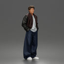 Urban male standing in varsity jacket and baggy trousers