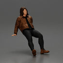 Man with long hair wearing brown jacket sitting with relaxed posture - Only-Games