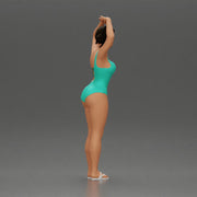 Brunette woman in turquoise swimsuit stretching with elegant ballet pose - Only-Games