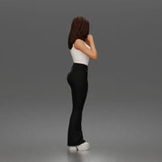 Thoughtful woman stands daydreaming wearing crop tank top and trousers - Only-Games