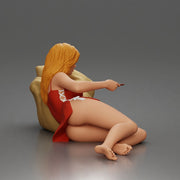 Woman lounges atop pillow watching television holding remote wearing slip dress - Only-Games