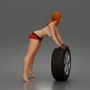 woman Pushing Tire In Bikini Top Shorts Tool Belt And Gloves