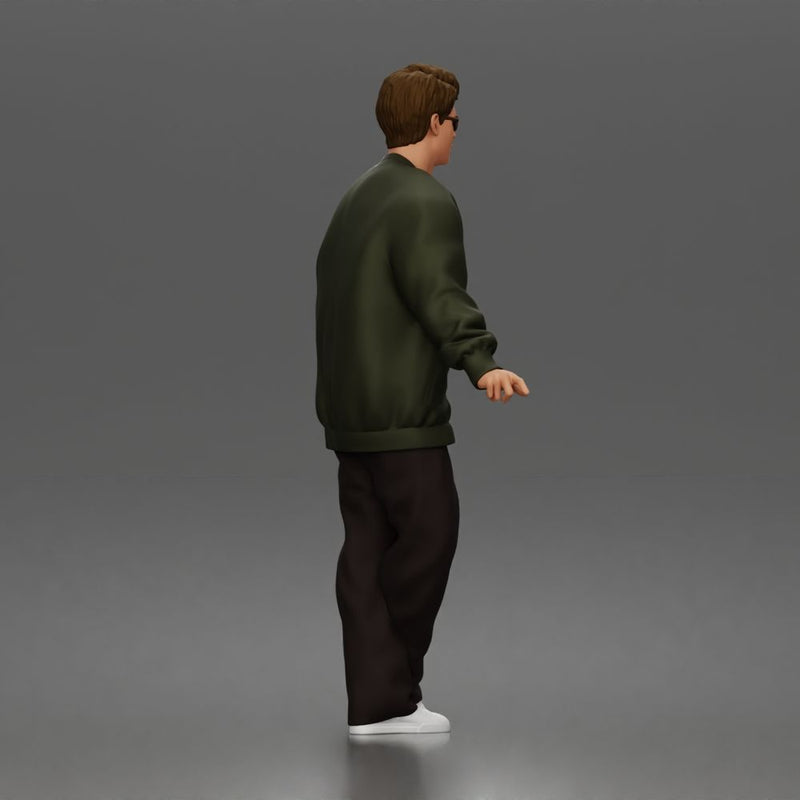 Man standing In Bomber Jacket Tee Trousers Sneakers And Sunglasses