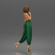 Woman poses thoughtfully lifting heel wearing halter jumpsuit with platform heels - Only-Games