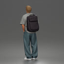 Student standing with backpack wearing oversized tee and baggy jeans