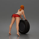 woman Pushing Tire In Bikini Top Shorts Tool Belt And Gloves