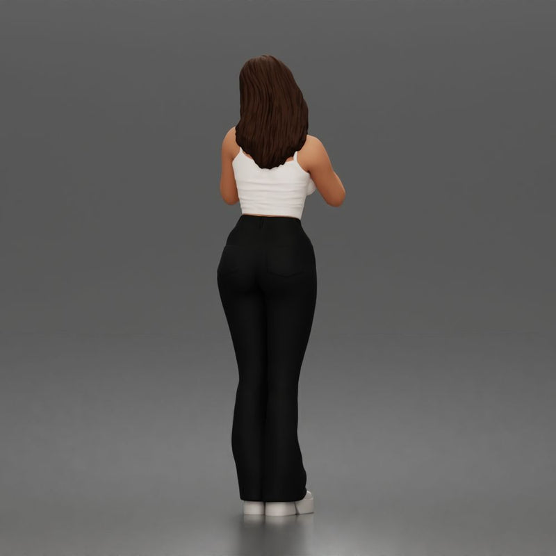 Thoughtful woman stands daydreaming wearing crop tank top and trousers - Only-Games