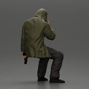 Man in hooded jacket sits alone holding gun feeling troubled - Only-Games
