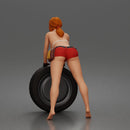 woman Pushing Tire In Bikini Top Shorts Tool Belt And Gloves