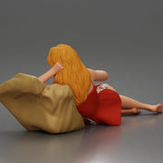 Woman lounges atop pillow watching television holding remote wearing slip dress - Only-Games