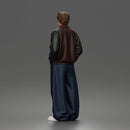 Urban male standing in varsity jacket and baggy trousers