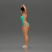 Brunette woman in turquoise swimsuit stretching with elegant ballet pose - Only-Games