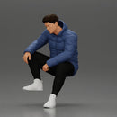 Street performer crouching low in blue puffer jacket athletic stance sitting - Only-Games