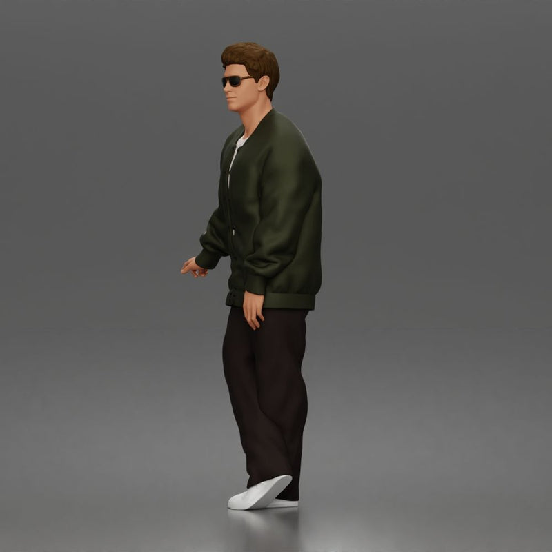 Man standing In Bomber Jacket Tee Trousers Sneakers And Sunglasses