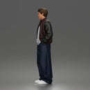 Urban male standing in varsity jacket and baggy trousers