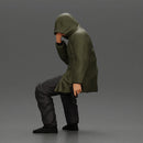 Man in hooded jacket sits alone holding gun feeling troubled - Only-Games