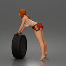 woman Pushing Tire In Bikini Top Shorts Tool Belt And Gloves