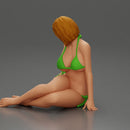Woman in green bikini sitting gracefully on the floor with a relaxed pose - Only-Games