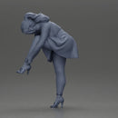 Young woman in skirt adjusts her elegant black high heeled shoes - Only-Games