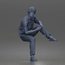 Man Sitting With Knee Bent In Shirt Trousers And Sandals