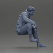 Street performer crouching low in blue puffer jacket athletic stance sitting - Only-Games