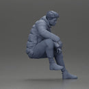 Street performer crouching low in blue puffer jacket athletic stance sitting - Only-Games