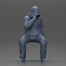 Man in hooded jacket sits alone holding gun feeling troubled - Only-Games