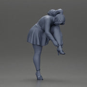 Young woman in skirt adjusts her elegant black high heeled shoes - Only-Games