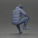 Street performer crouching low in blue puffer jacket athletic stance sitting - Only-Games