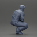 Gangster man crouching in a relaxed pose wearing casual clothing and cap - Only-Games